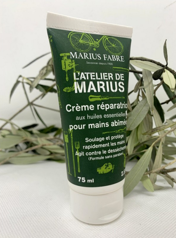Tube de crème mains posée devant des herbes