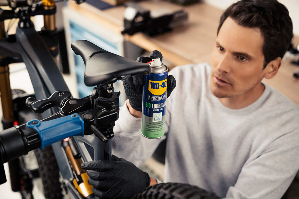 Homme qui utilise le Lubrifiant Dégrippant Bio WD-40 pour son vélo
