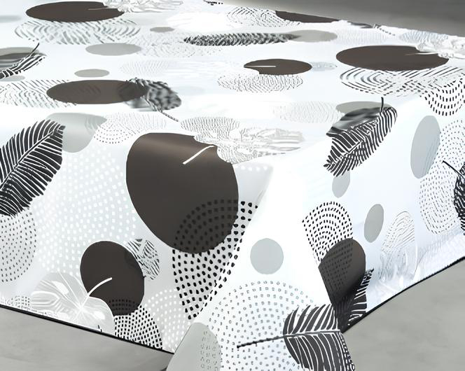 Nappe rectangulaire 140 cm x 240 cm en polyester avec motif végétal graphique noir, gris et blanc, associant feuillages stylisés et formes abstraites pour une décoration moderne et épurée.