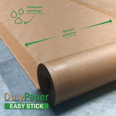 Rouleau de papier de protection DulyPaper Easy Stick hydrofuge avec bandes adhésives pour sols.