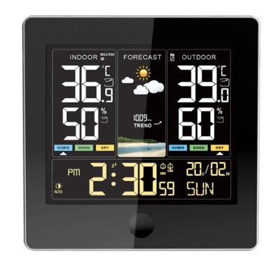 Station météo numérique avec cadre noir affichant l'heure, la date, ainsi que les prévisions météorologiques, les températures et les taux d'humidité intérieurs et extérieurs sur un écran couleur.
